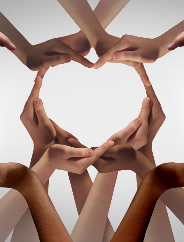 Unity and Togetherness or diversity partnership as heart hands in a group of diverse people connected together shaped as a support symbol expressing the feeling of teamwork.