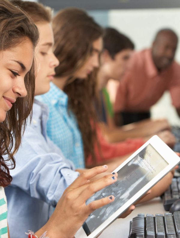 Girl Using Digital Tablet In Computer Class