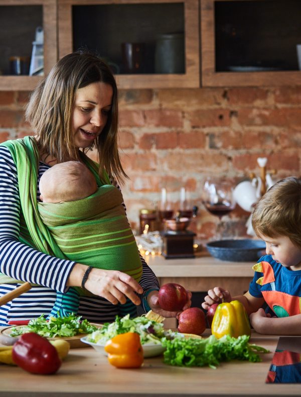 Young family, mother with two children cooking at home